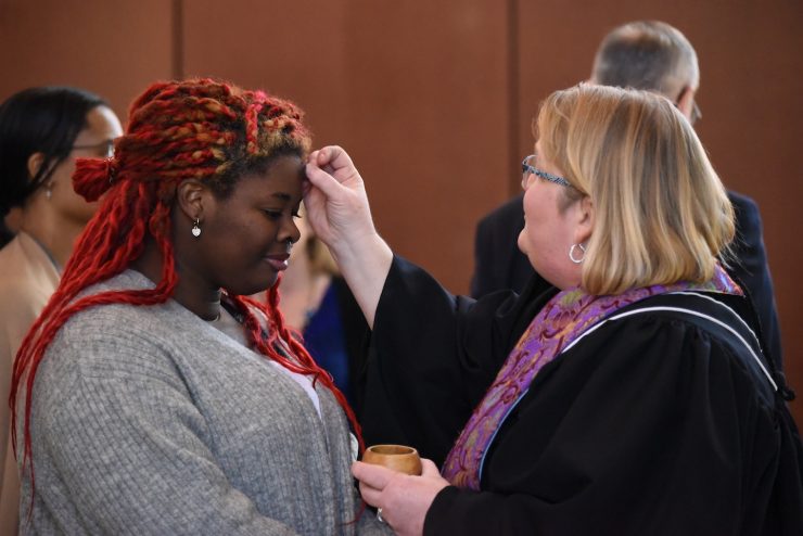 Reverend Kelli Taylor places ash on the forehead of a Methodist University student on Ash Wednesday