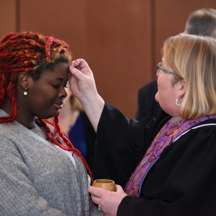 Reverend Kelli Taylor places ash on the forehead of a Methodist University student on Ash Wednesday