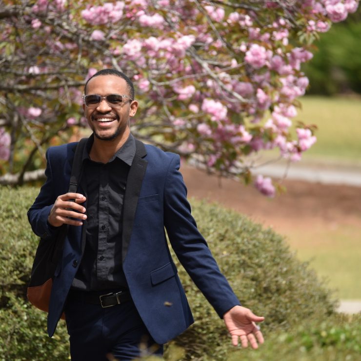 Happy smiling student walking on Methodist University campus