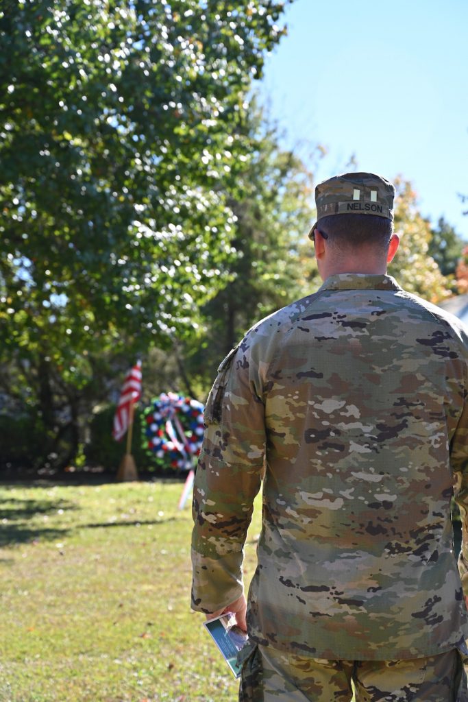 Veteran standing next to a wreath