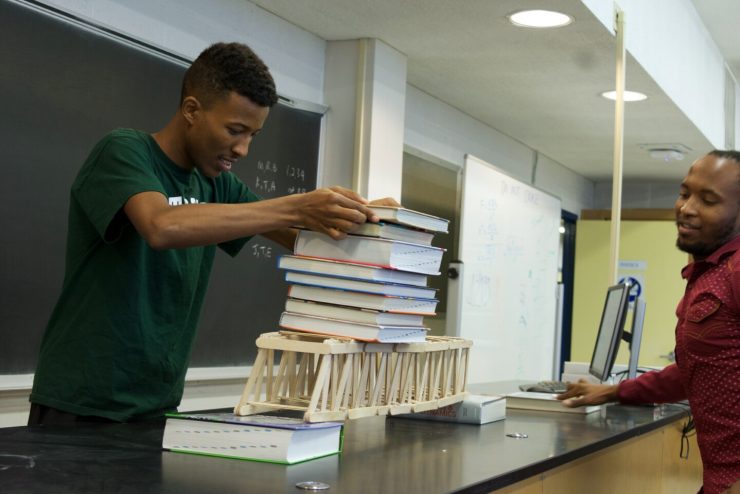 Students add weight to a model bridge