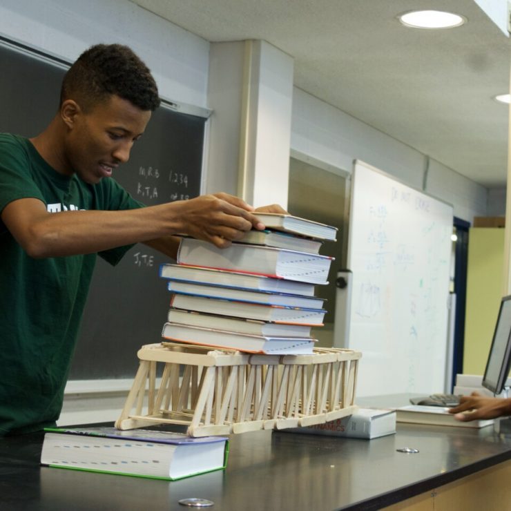 Students add weight to a model bridge