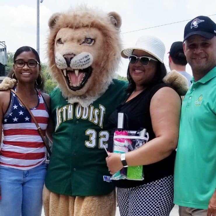 Mascot King poses with a family at a Fayetteville Woodpeckers game