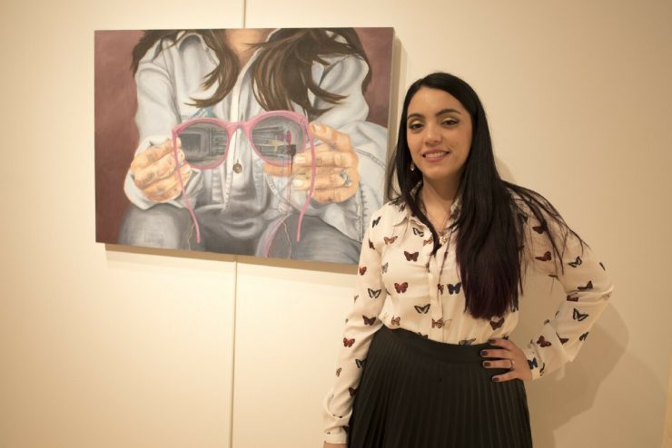 Student Loreto Oreckinto poses with her painting