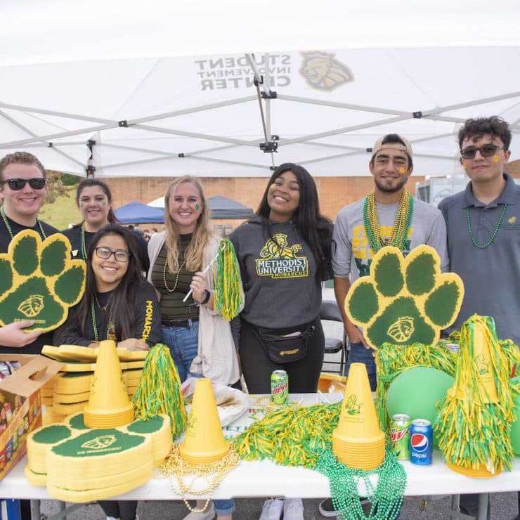 Methodist University students hang out together at a Homecoming tailgate