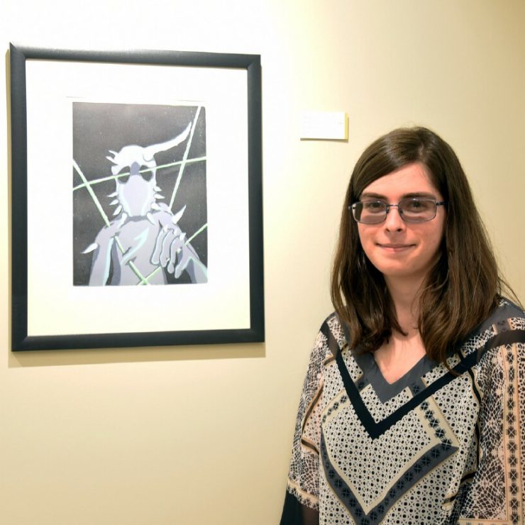 Student Kristen Oliva poses with her artwork in the Union-Zukowski Lobby & Gallery