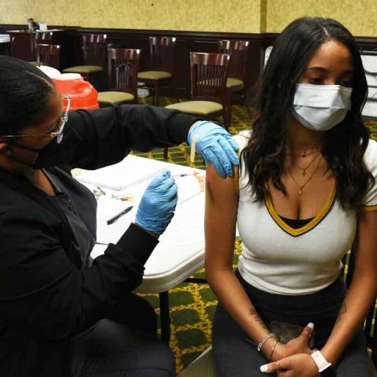 A student receives a COVID-19 vaccination at a campus clinic
