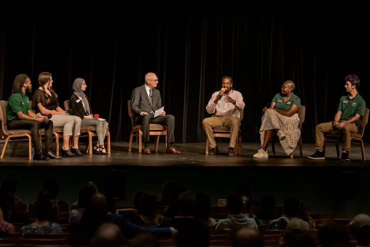 Methodist University's 2022 Fall Convocation focused on a panel discussion between (from left to right) senior Kobe Praylow, sophomore Rebecca McGaughnea, graduate student Zahra Asif, President Stanley T. Wearden, graduate student Raymond McCall, sophomore Asemahle Mgayi, and sophomore Zachary Butrite.