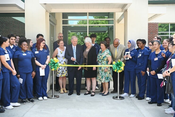 During a ceremony on Friday for Methodist University's newly-named Robert J. Chaffin building, Chaffin's nephew Sam Byrd (center left) and niece Valerie Chaffin (center right) are surrounded by students, faculty, and staff as they cut a ribbon to officially signify the naming of the building.