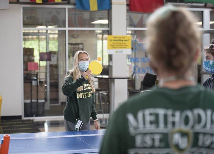 Students play ping-pong in Berns while masked