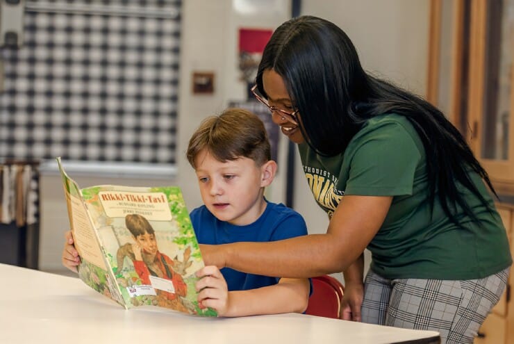 Methodist University student Epiphany McGirt, an Elementary Education major, works with 4th grader Davin Redcay to practice spelling different multisyllabic words using letter tiles.