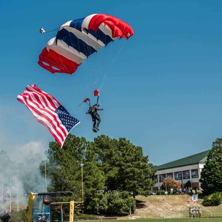 The All-Veteran Group parachute team lands on the Monarch Stadium field prior to the football game during Saturday's Military Appreciation Day at Methodist University.