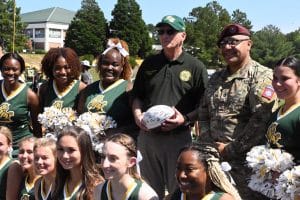 Sergeant First Class Kevin Quinones of the 82ndAirborne Division is given the ceremonial game ball by Dr. Stanley T. Wearden, President of Methodist University, during Saturday's Military Appreciation Day football game at MU