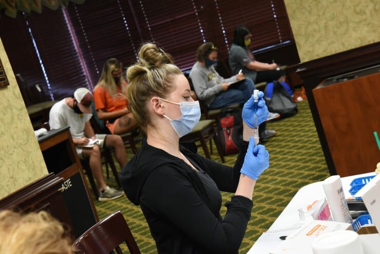 A nurse at the vaccine clinic readies a shot