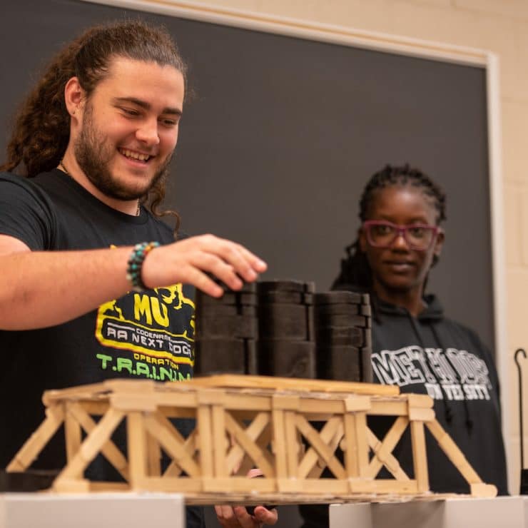 Students test their bridges during an Engineering class at Methodist University