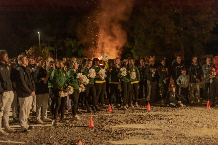 On Friday night, Methodist University students watch a dance performance as a bonfire burns behind them in the parking lot behind the Riddle Athletics Center.