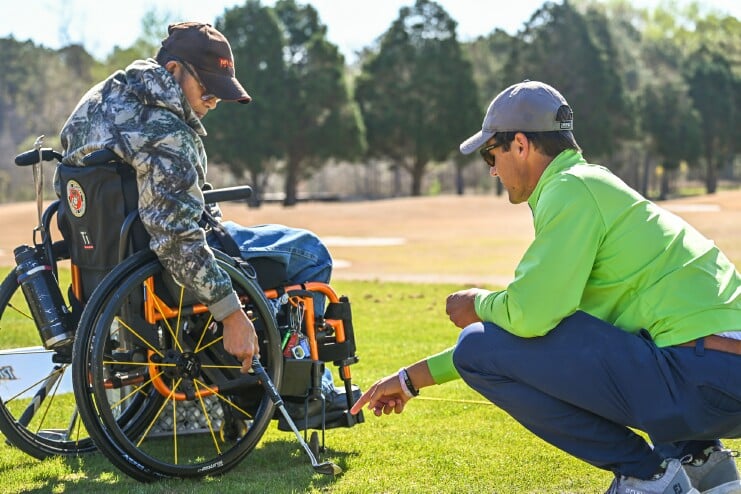 PGA Golf Management staff works with a veteran at the Driving Range