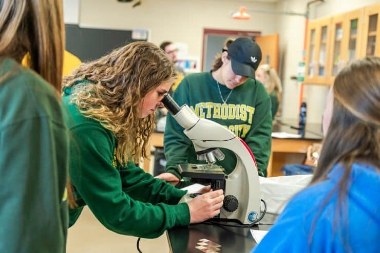 Biology students look through a microscope