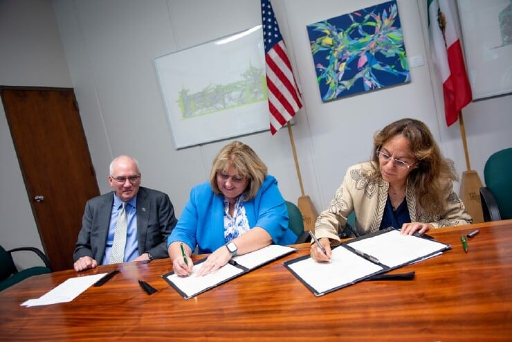 Dr. Stanley T. Wearden, left, looks on as Dawn Ausborn, VP of Finances, signs a memorandum of understanding with the Consulate General of Mexico.
