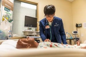 Lee, a nursing student, works with a manakin