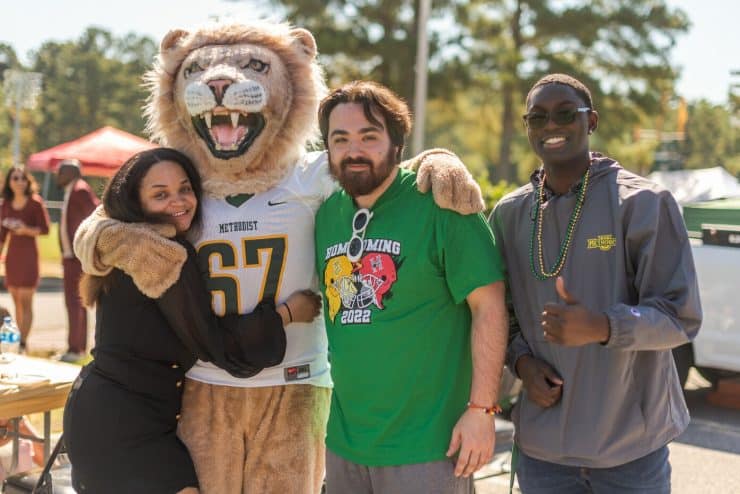 Mascot King poses with students at Homecoming