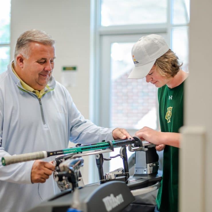 Methodist University PTM students learns how to use a racket stringer.