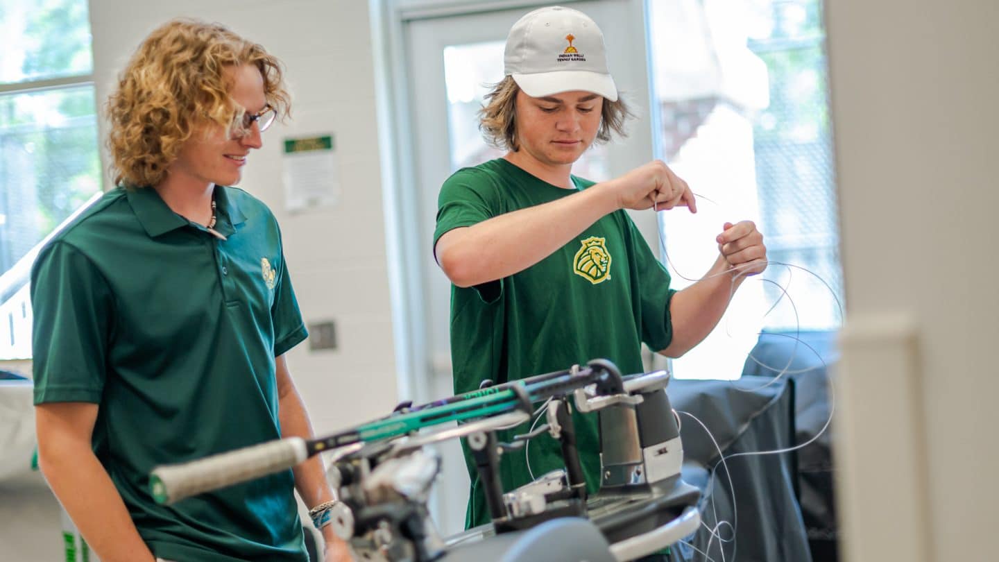 Professional Tennis Management students work on racquet repair