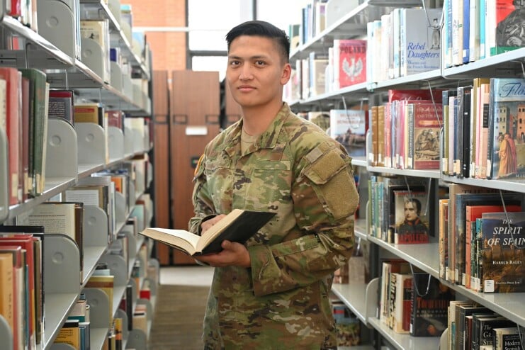 Active-duty military member stands in the Davis Memorial Library at Methodist University