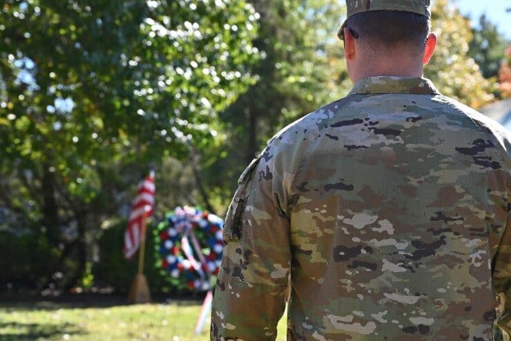 Veteran stands in front of an American flag during Methodist University's veteran service
