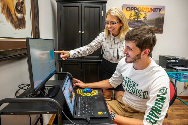 Marketing Professor Samantha Inczauskis assists a student