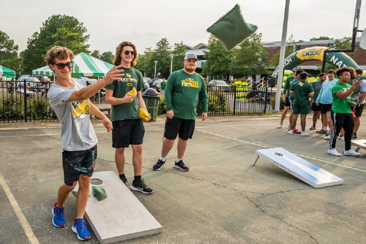 Students play cornhole at Kick Back with the Monarchs event