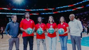 Nahsir Knight-Bell (third from left) accepts a customized basketball during a Charlotte Hornets game.