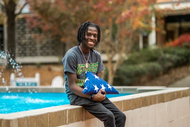 Nahsir Knight-Bell sits with a flag commemorating his father's service to our country.