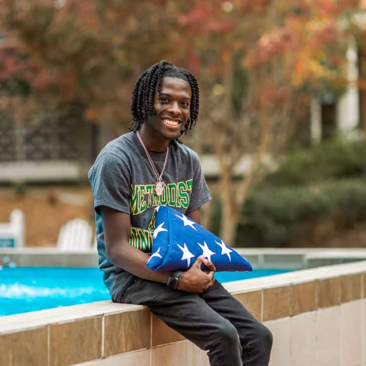 Nahsir Knight-Bell sits with a flag commemorating his father's service to our country.