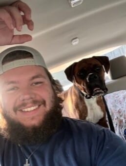 Logan Hilton and a dog in a car
