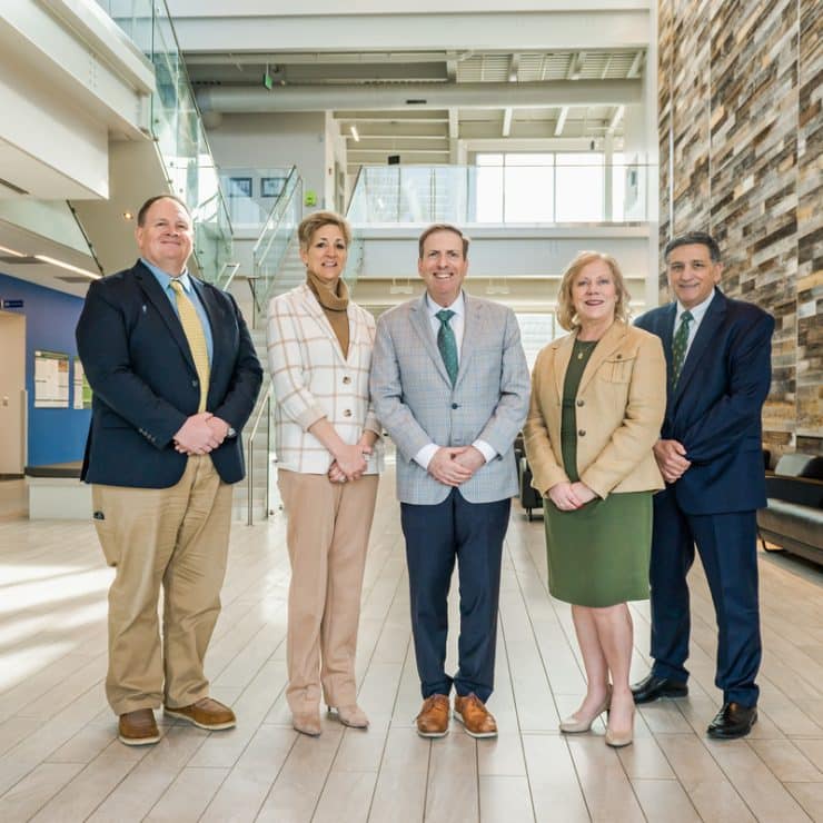 The Methodist University Cape Fear Valley Health School of Medicine leadership team stands in Methodist University's McLean Health Sciences Building (left to right): Scott Bullard (Chief of Staff), Dr. Stephanie Mann (Senior Associate Dean for Academic Affairs), Dr. Hershey Bell (Founding Dean), Dr. Kimberly Vess (Senior Associate Dean for Student Experience), and John Worth (Senior Associate Dean for Administration and Finance).