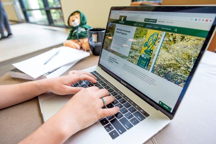 A student browses the Methodist University Online Web site on a laptop