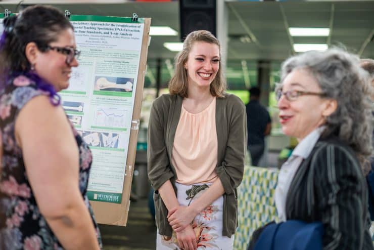 A student makes a Poster Presentation