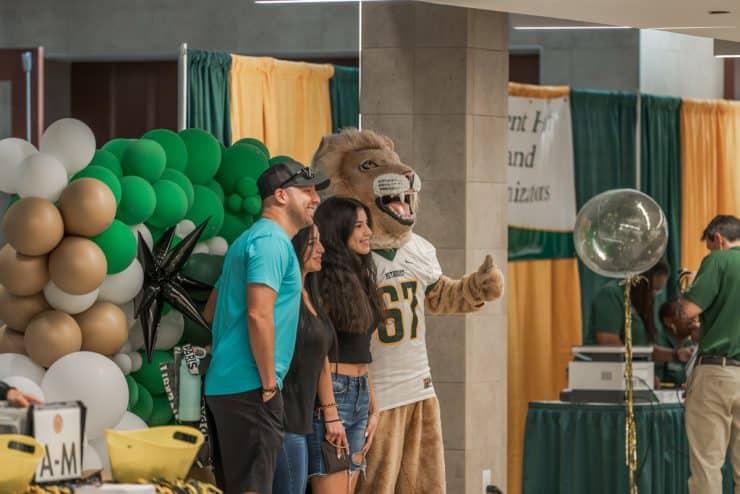 New student poses with parents and King