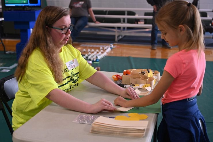 Student volunteer Caitlyn Keplinger helps a child learn