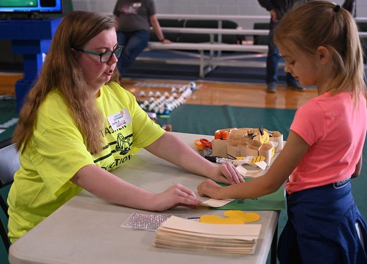 Student volunteer Caitlyn Keplinger helps a child learn