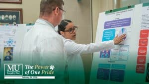 A student presents at a research symposium with the Methodist University Loyalty Day logo