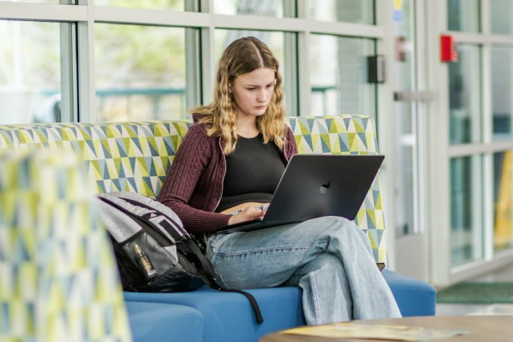 A student works on her Mac Laptop