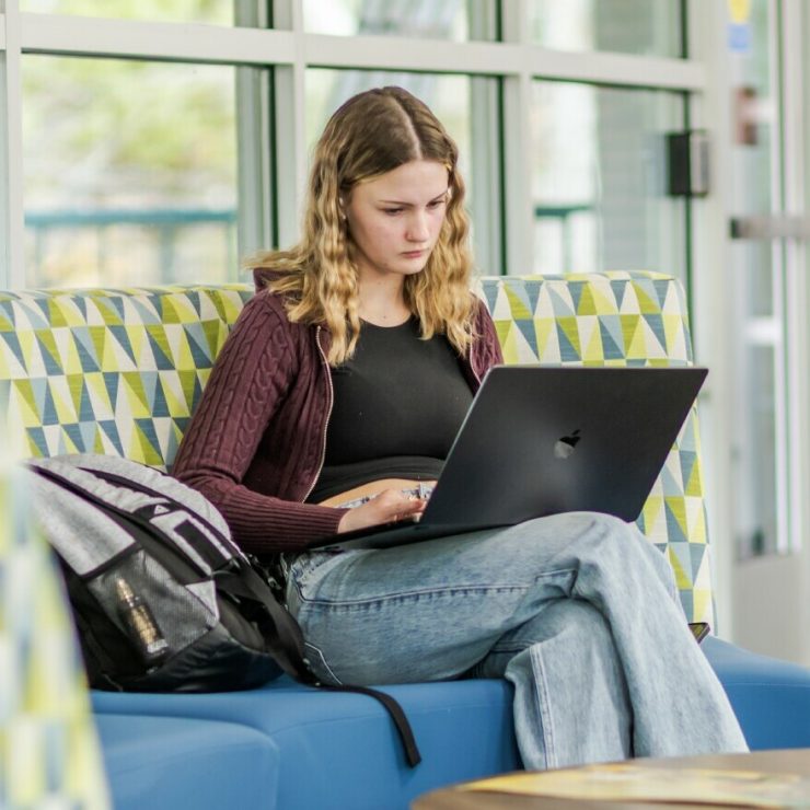 A student works on her Mac Laptop