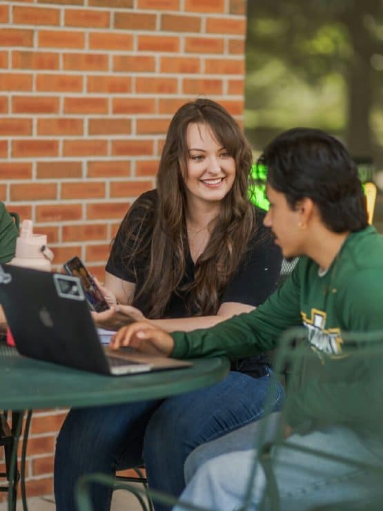 Students work on their computers outside Matthews Ministry Center