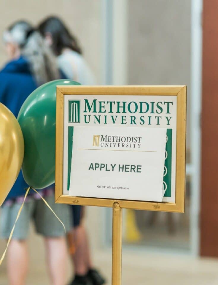 A sign encouraging prospective students to apply here.