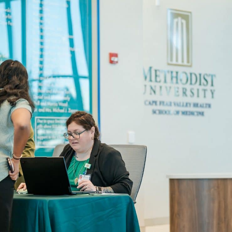 A School of Medicine admissions representative greets a prospective student
